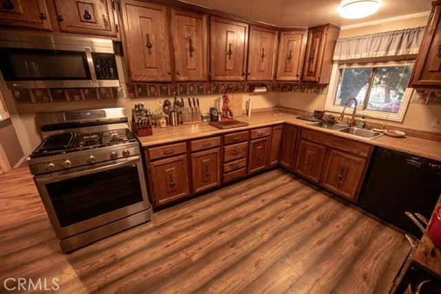 a kitchen with stainless steel appliances granite countertop a stove a sink and a microwave