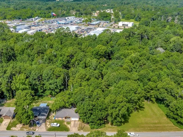 an aerial view of residential house with outdoor space and trees all around