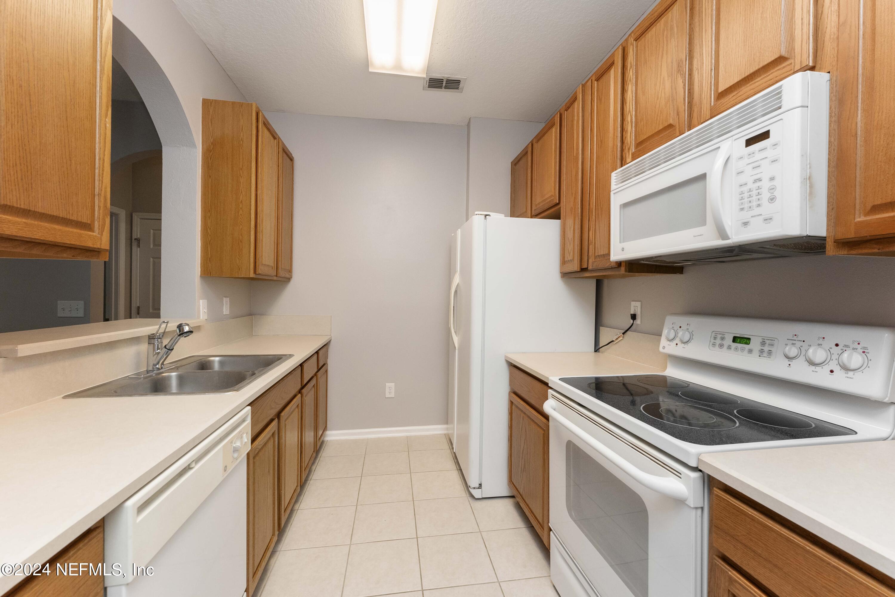 7801 Point Meadows Drive, Unit 5202 Jacksonville, FL 32256 - Photo 11 of 34 a kitchen that has a sink and a stove