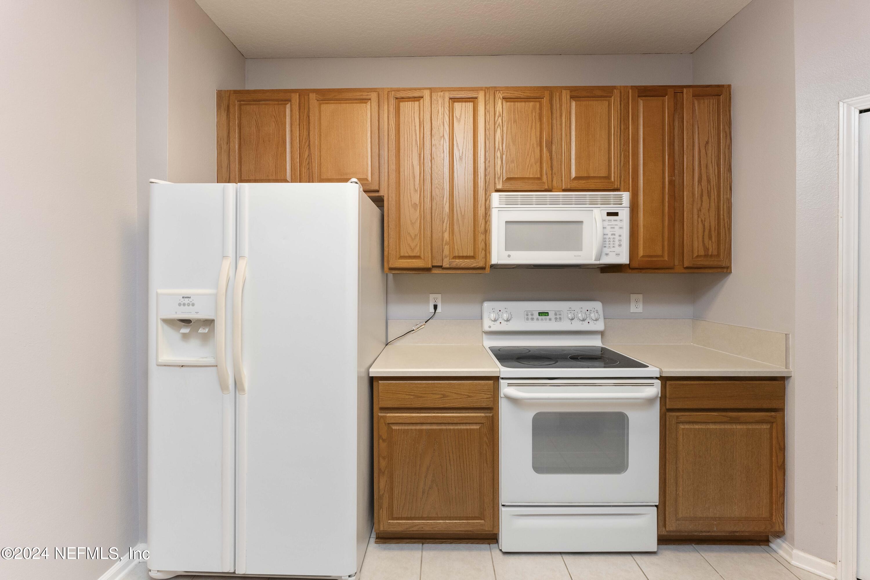 7801 Point Meadows Drive, Unit 5202 Jacksonville, FL 32256 - Photo 12 of 34 a kitchen with a stove and a refrigerator