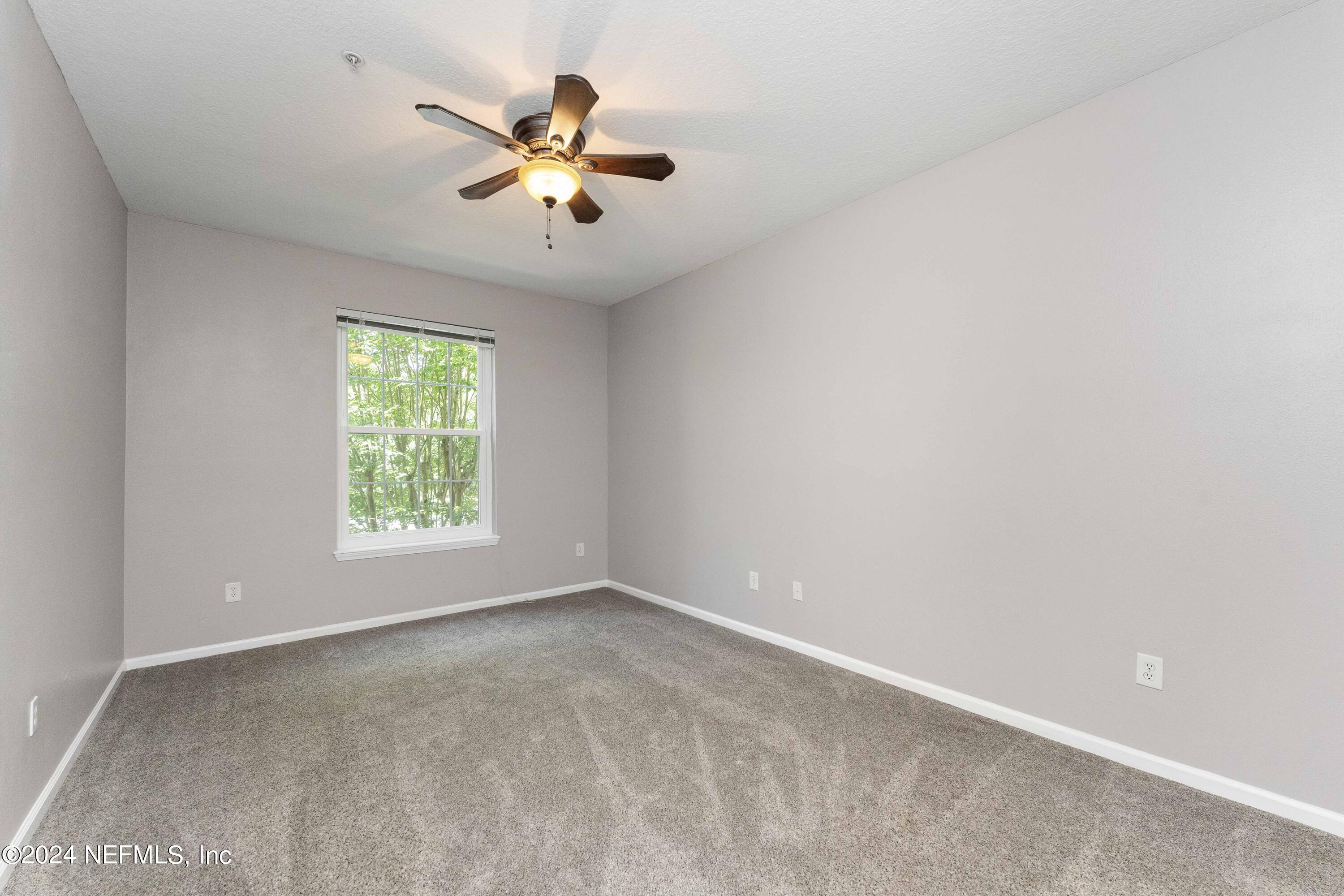 7801 Point Meadows Drive, Unit 5202 Jacksonville, FL 32256 - Photo 20 of 34 an empty room with a window and a fan