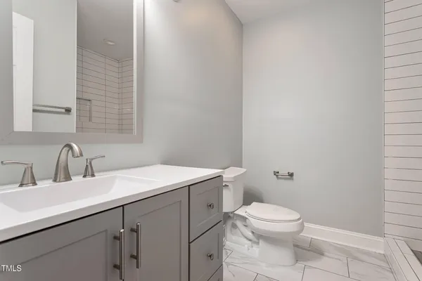 a bathroom with a sink a toilet and a mirror