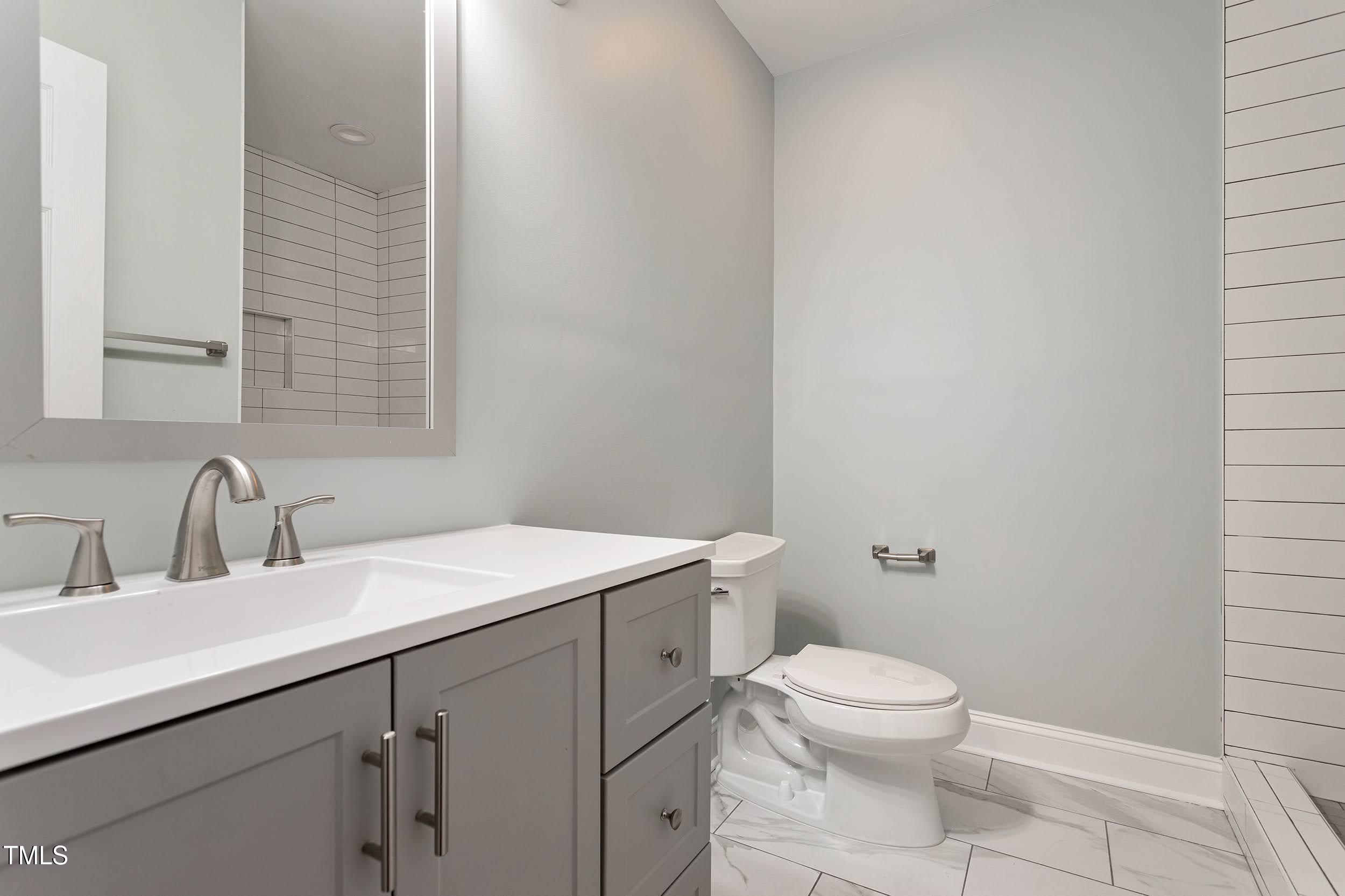 2700 University Drive, Unit B Durham, NC 27707 - Photo 12 of 17 a bathroom with a sink a toilet and a mirror