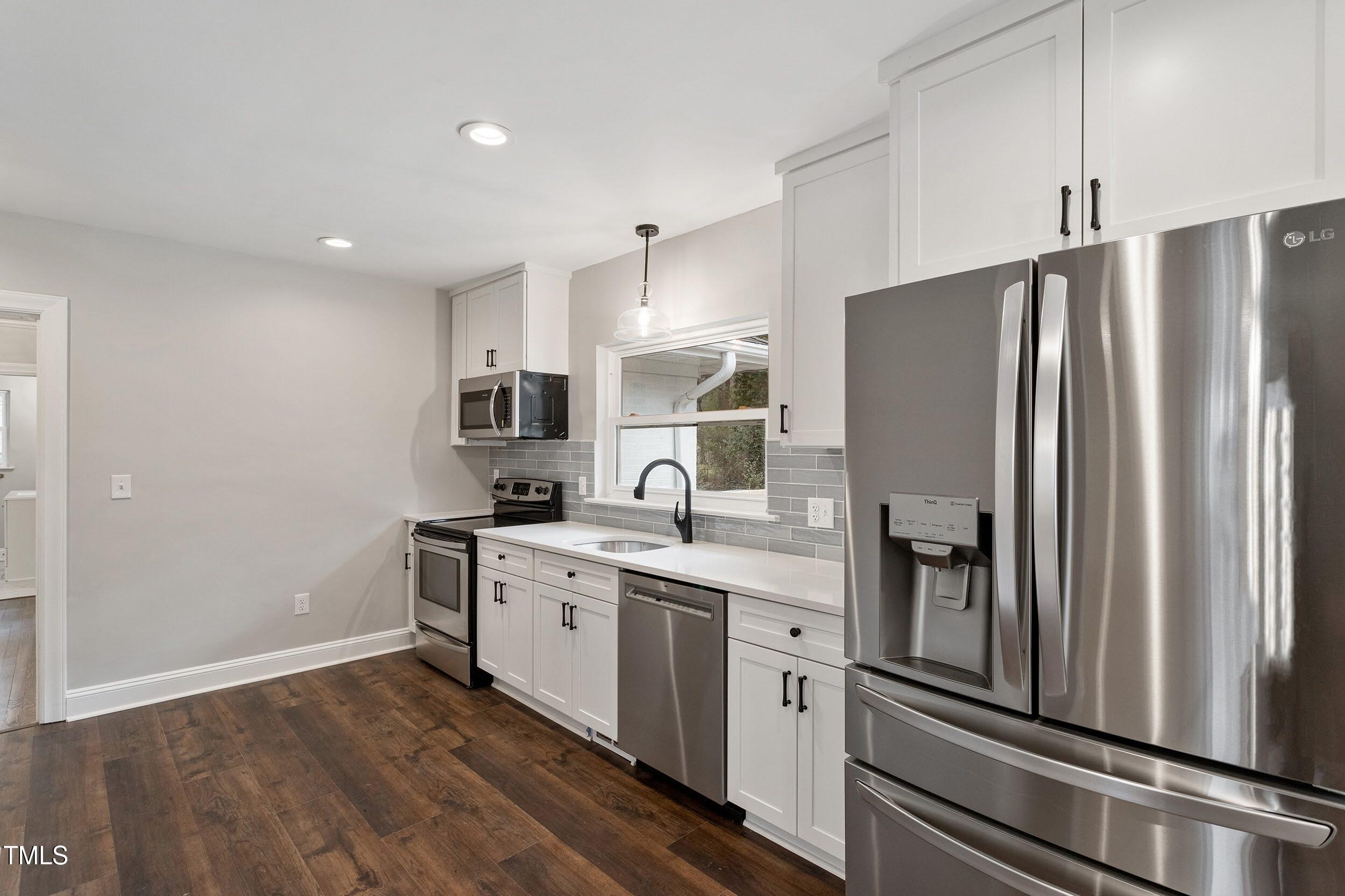 2700 University Drive, Unit B Durham, NC 27707 - Photo 5 of 17 a kitchen with stainless steel appliances a refrigerator sink and stove