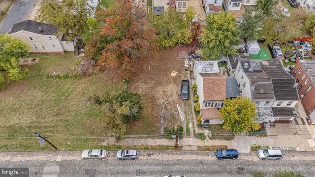 an aerial view of a house with a yard and large tree