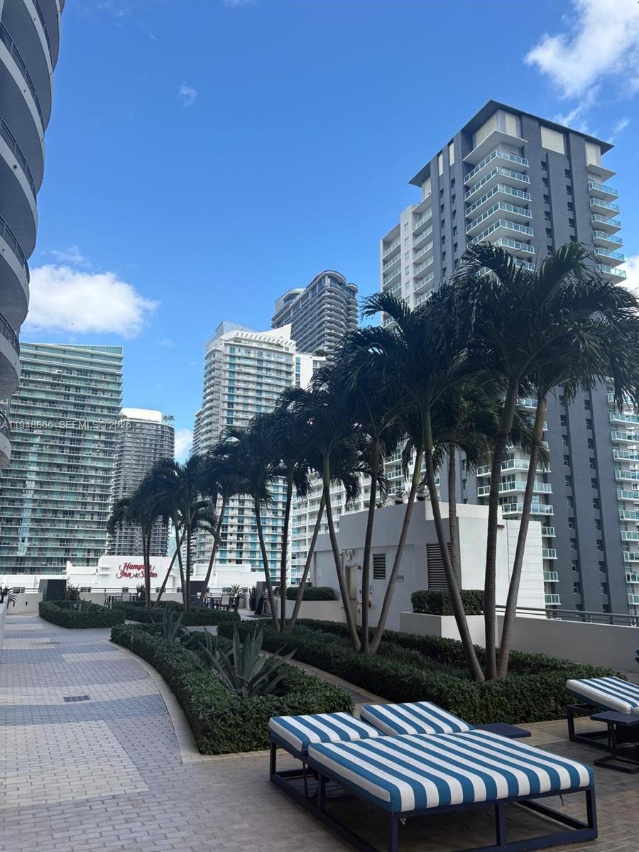 60 Southwest 13th Street, Unit 3013 Miami, FL 33130 - Photo 20 of 26 a view of a patio with a table and chairs and wooden fence