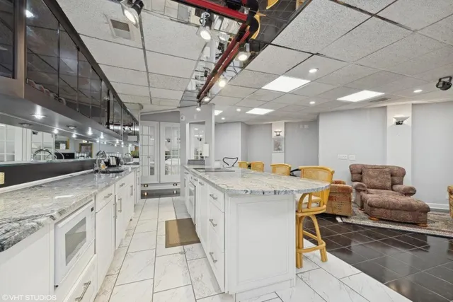 a view of a kitchen and kitchen with stainless steel appliances granite countertop lots of counter top space