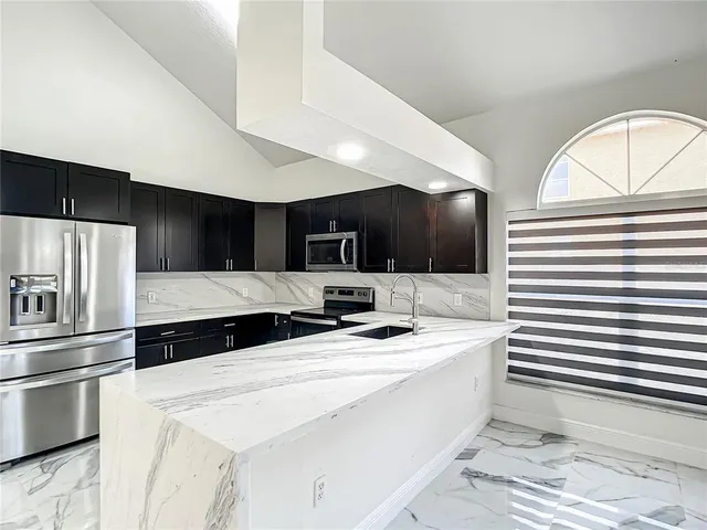 a kitchen with stainless steel appliances a sink a stove a microwave and cabinets