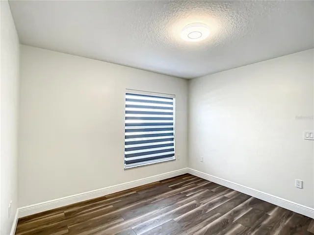 a view of an empty room with closet and a window