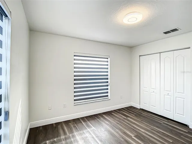 a view of a room with wooden floor and a window