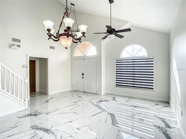 a view of a room with a chandelier fan and windows