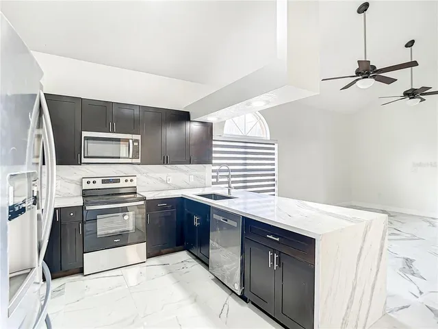 a kitchen with stainless steel appliances granite countertop a sink and stove top oven