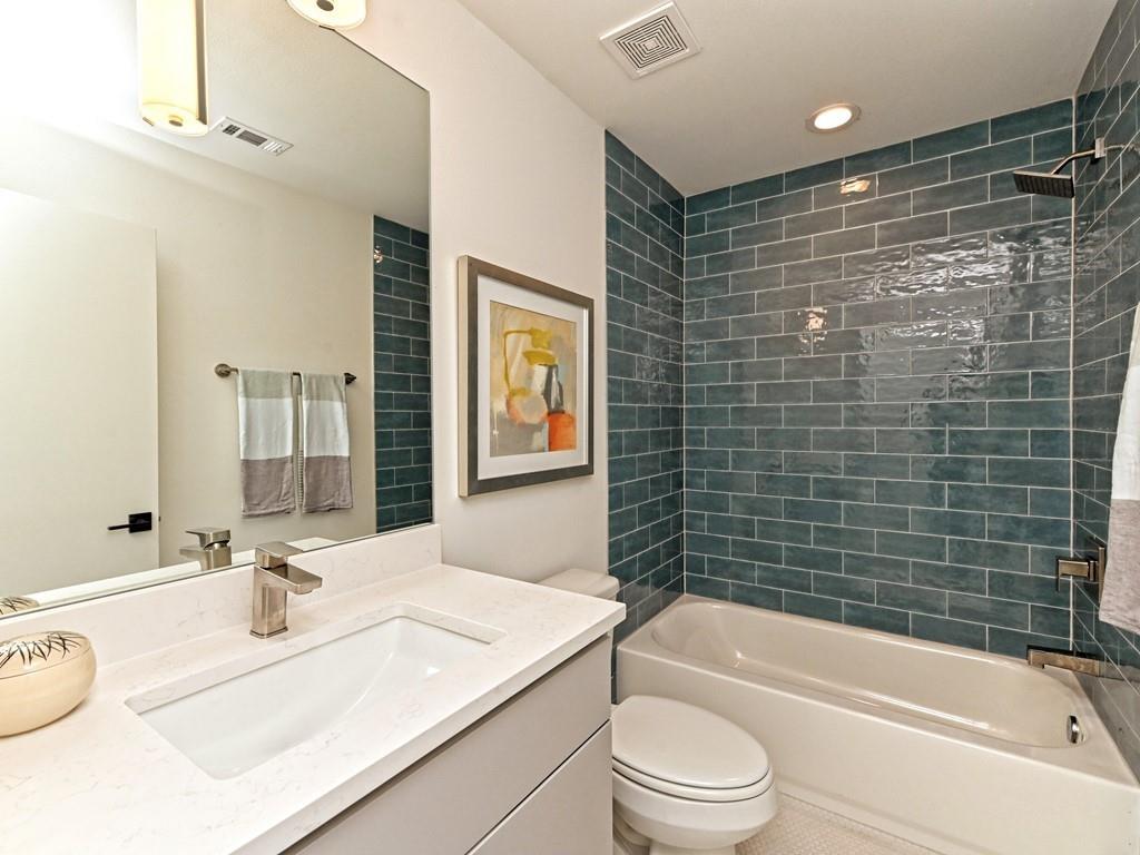 1116 Atkinson Road Austin, TX 78752 - Photo 11 of 27 a bathroom with a granite countertop bathtub sink vanity mirror and toilet
