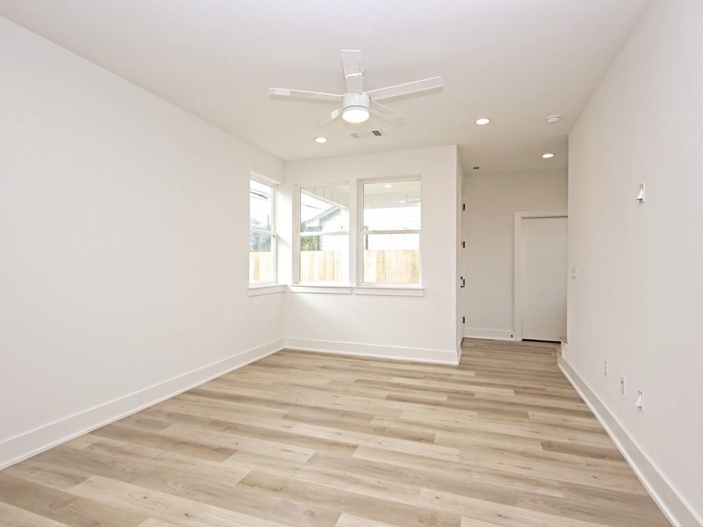 1116 Atkinson Road Austin, TX 78752 - Photo 12 of 27 an empty room with wooden floor and windows