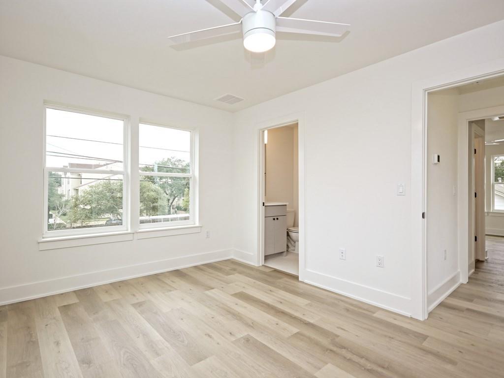 1116 Atkinson Road Austin, TX 78752 - Photo 16 of 27 an empty room with wooden floor fan and windows