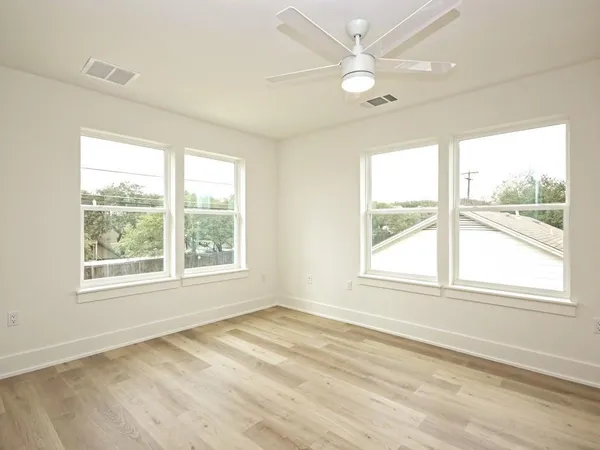 an empty room with a window and a ceiling fan
