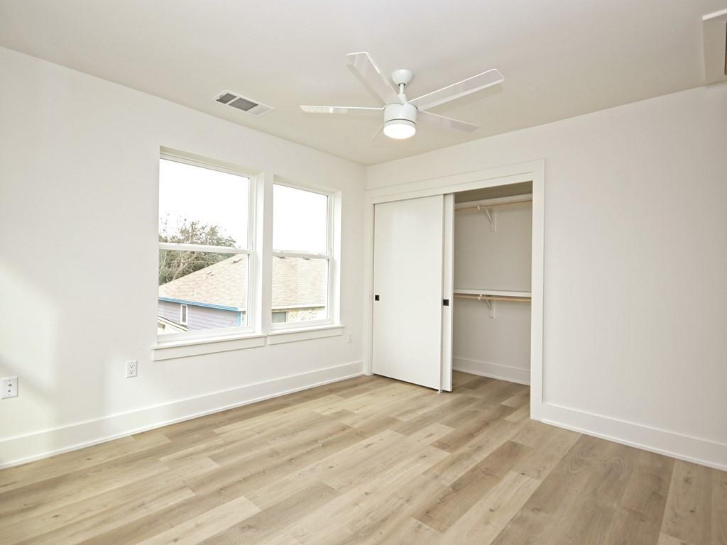 1116 Atkinson Road Austin, TX 78752 - Photo 22 of 27 an empty room with wooden floor closet and windows