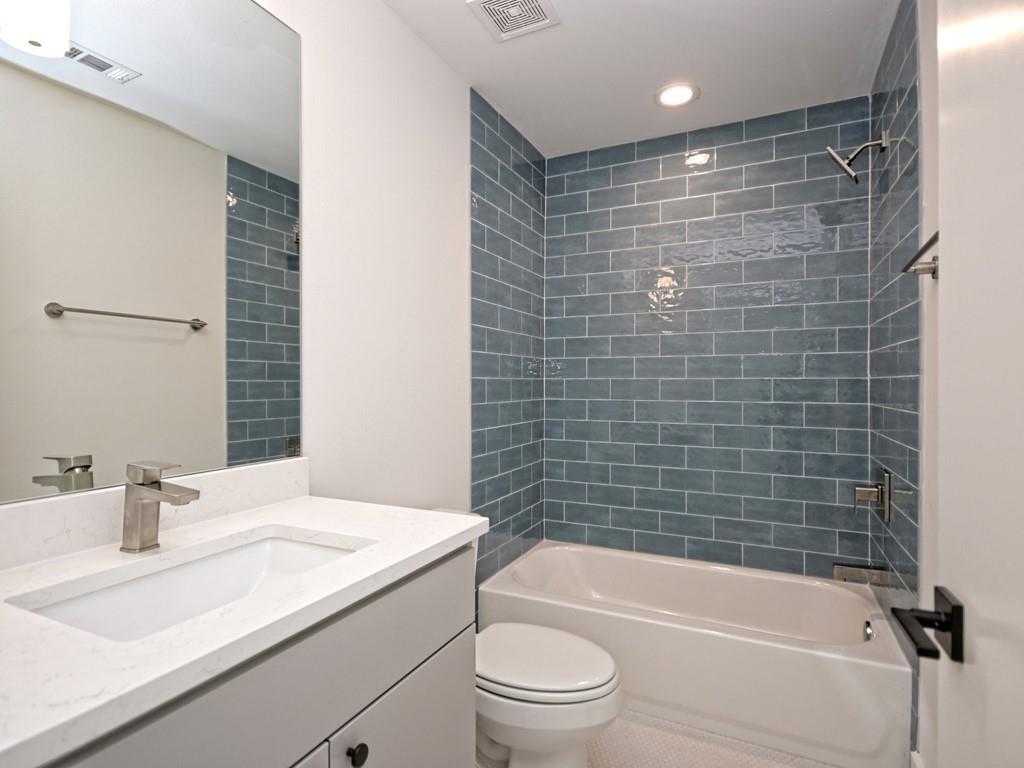 1116 Atkinson Road Austin, TX 78752 - Photo 23 of 27 a bathroom with a granite countertop bathtub shower sink vanity and toilet