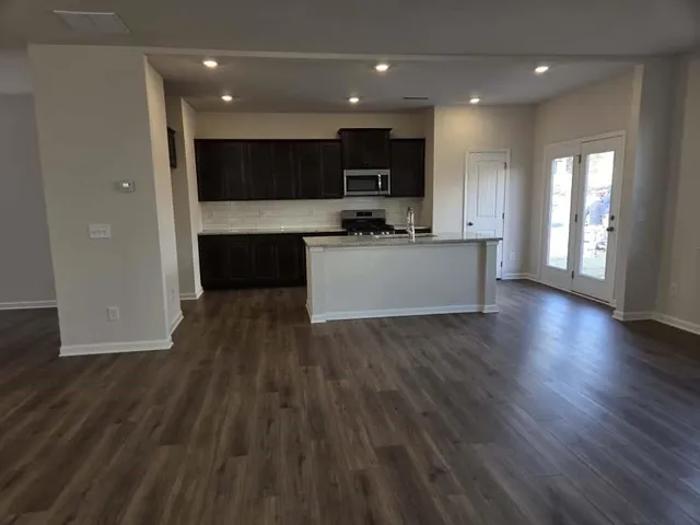 a kitchen with stainless steel appliances granite countertop a stove a sink and a microwave