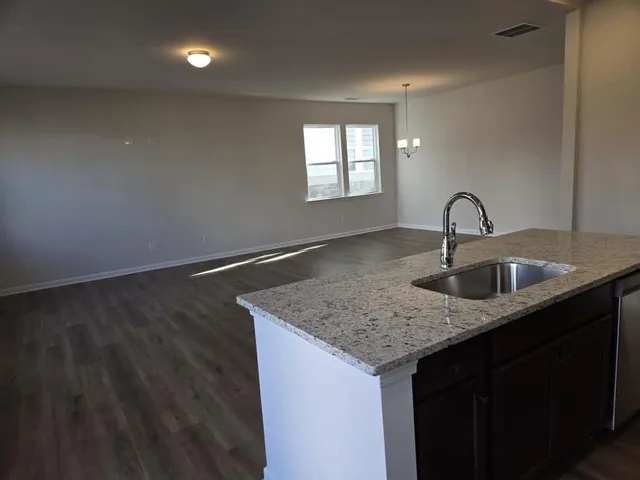 a view of kitchen with stainless steel appliances wooden floor and wooden cabinets