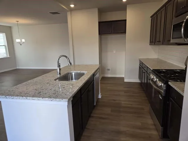 a kitchen with stainless steel appliances granite countertop a stove microwave and sink