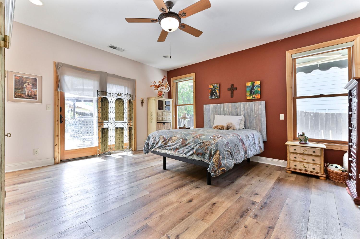281 Oak Tree Circle Murphys, CA 95247 - Photo 19 of 96 a bedroom with a large bed a large window and glass walk in closet