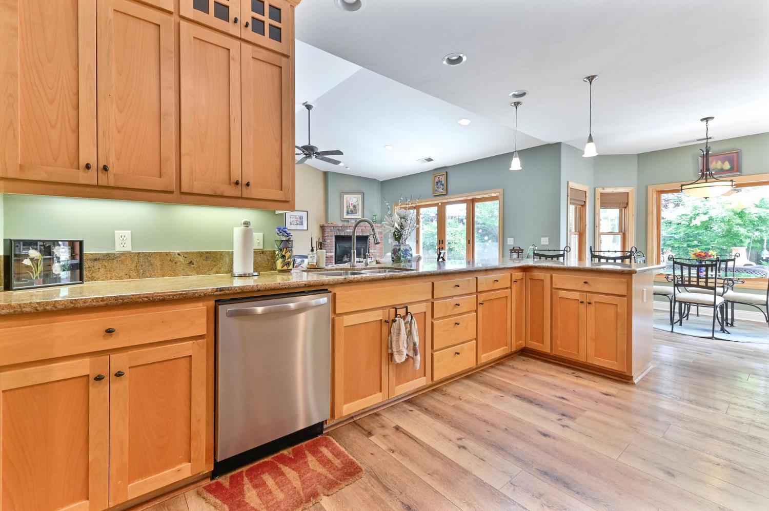 281 Oak Tree Circle Murphys, CA 95247 - Photo 47 of 96 a kitchen with stainless steel appliances granite countertop wooden cabinets a sink and dishwasher with wooden floor