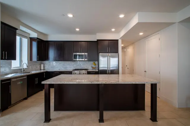 a large kitchen with stainless steel appliances granite countertop a sink and a stove