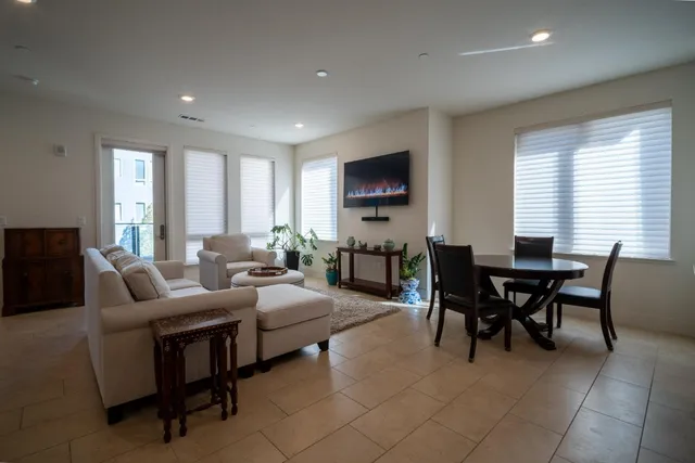 a living room with furniture a flat screen tv and a window