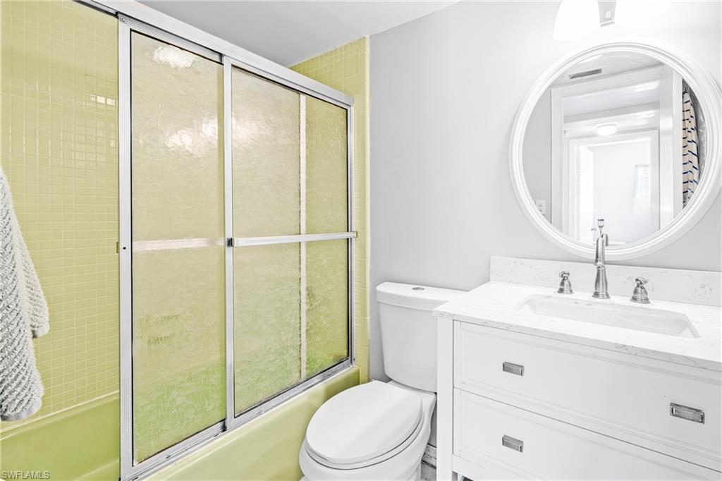 345 Joel Boulevard, Unit 110 Lehigh Acres, FL 33936 - Photo 17 of 47 a bathroom with a toilet a sink and a mirror