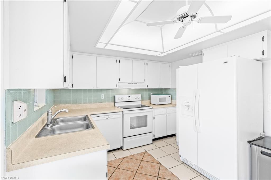 345 Joel Boulevard, Unit 110 Lehigh Acres, FL 33936 - Photo 23 of 47 a kitchen with a sink a stove a refrigerator and cabinets