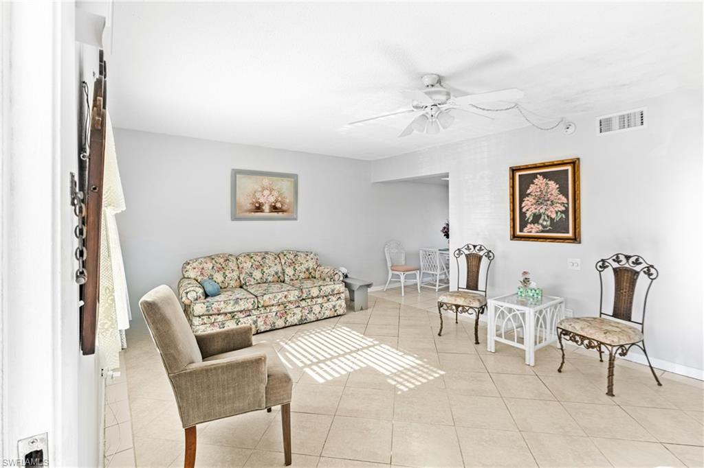 345 Joel Boulevard, Unit 110 Lehigh Acres, FL 33936 - Photo 9 of 47 a living room with furniture and painting on the wall