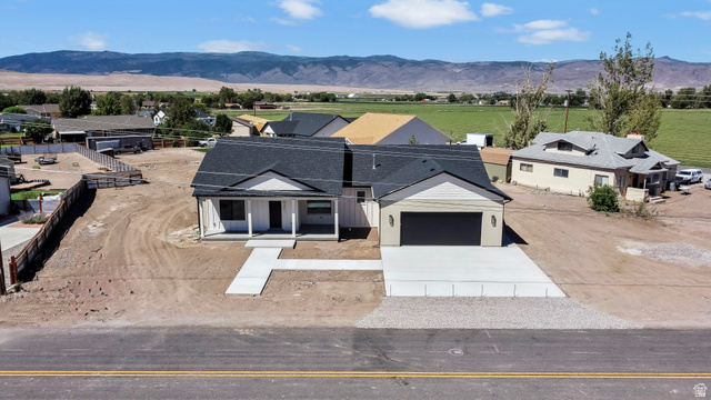 840 South Jones Road Monroe, UT 84754 - Photo 37 of 52 Newly constructed residence with a dark shingle roof, white siding, and an attached two-car garage