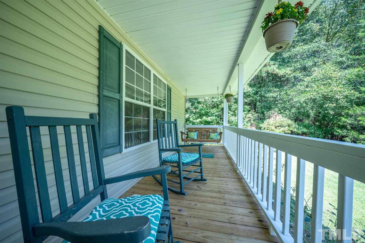 190 Landmark Road Willow Spring, NC 27592 - Photo 2 of 25 a balcony with wooden floor table and chairs