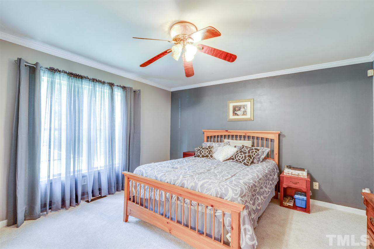 190 Landmark Road Willow Spring, NC 27592 - Photo 11 of 25 a bedroom with a bed and a chandelier