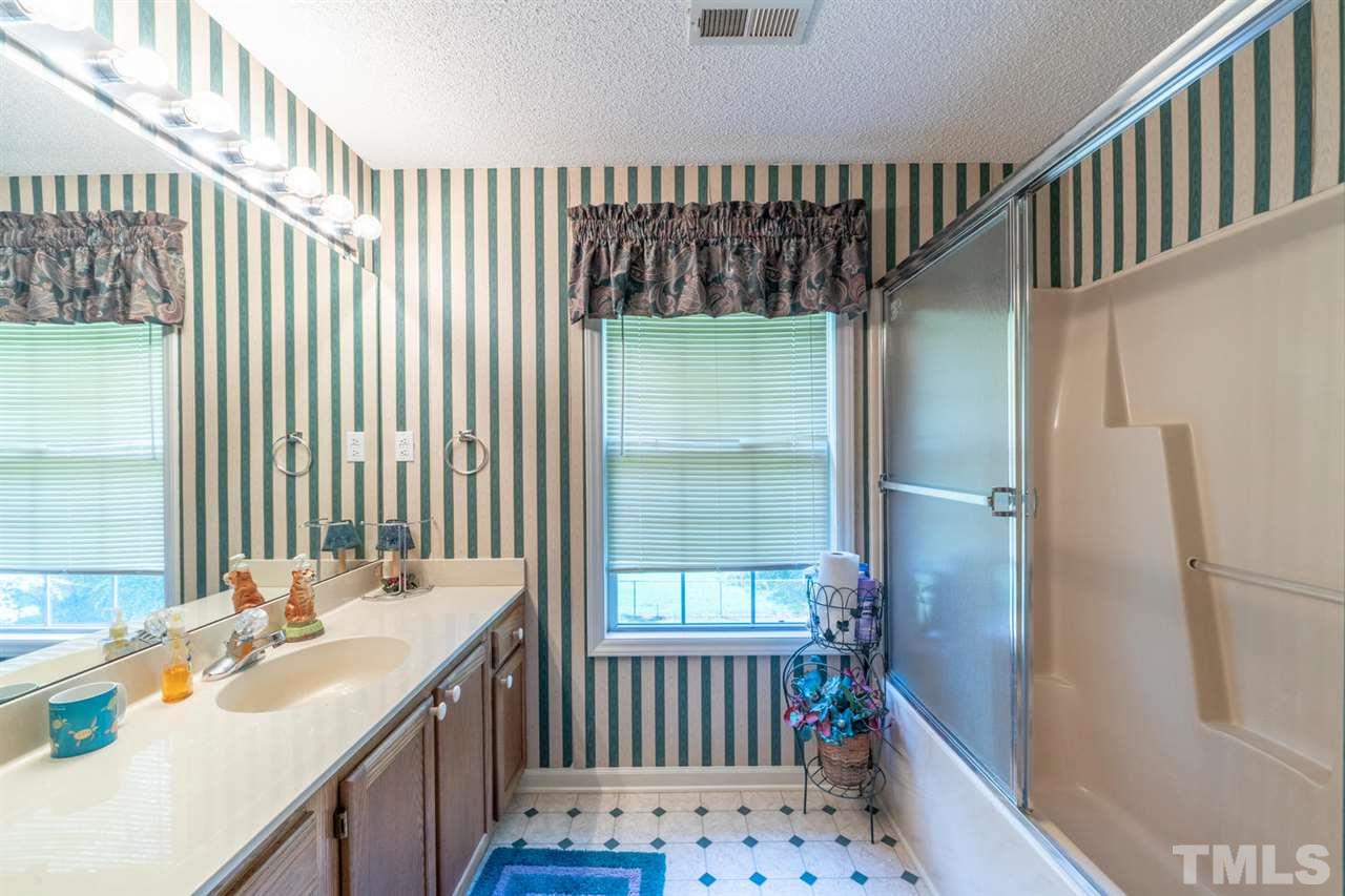 190 Landmark Road Willow Spring, NC 27592 - Photo 17 of 25 a bathroom with a sink and a large mirror