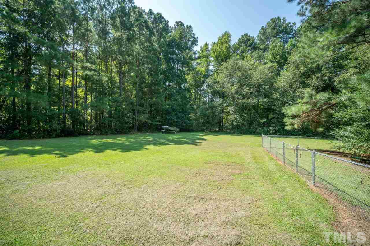 190 Landmark Road Willow Spring, NC 27592 - Photo 20 of 25 a view of a big yard with large trees