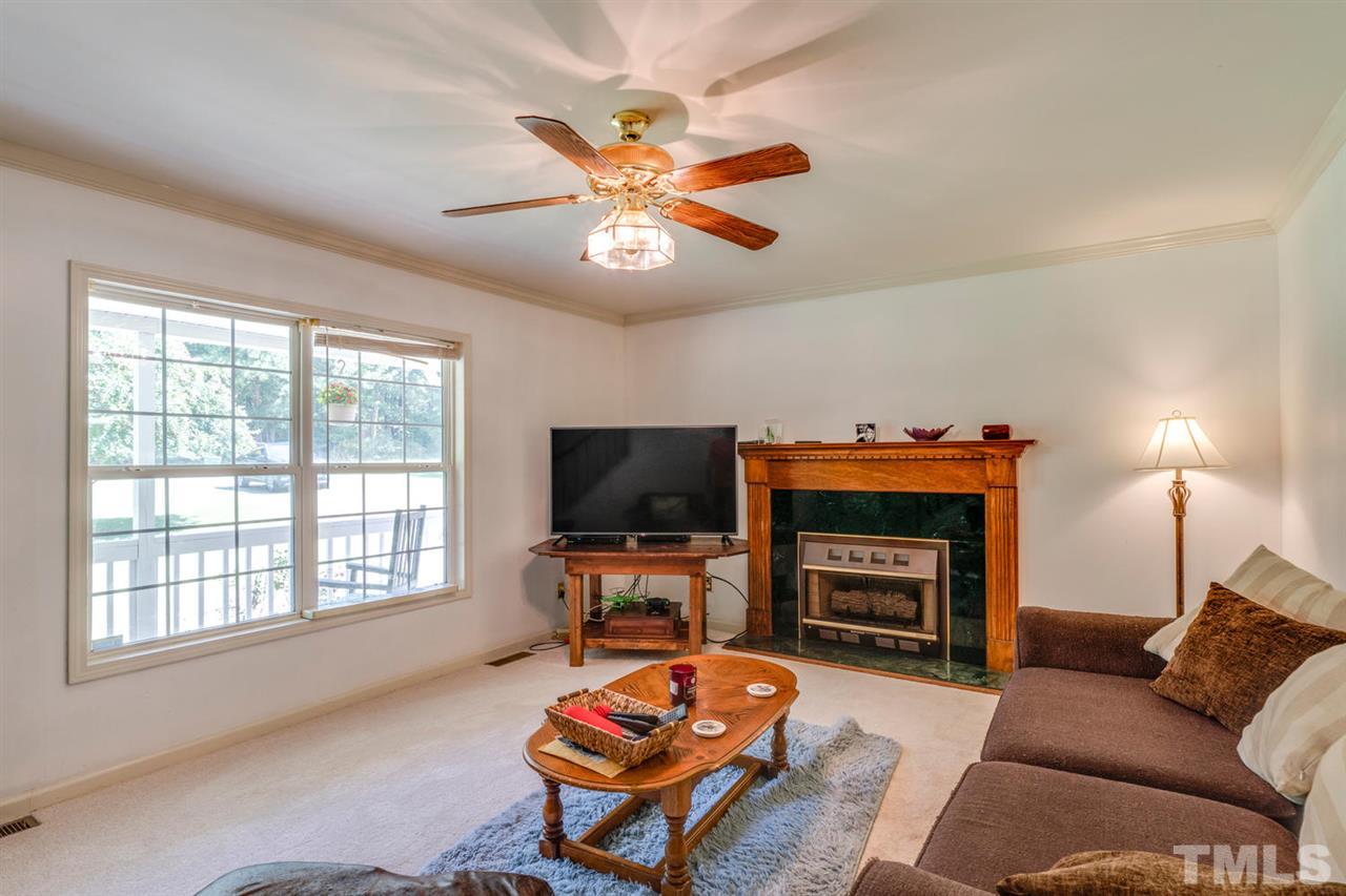 190 Landmark Road Willow Spring, NC 27592 - Photo 4 of 25 a living room with furniture a fireplace and a flat screen tv