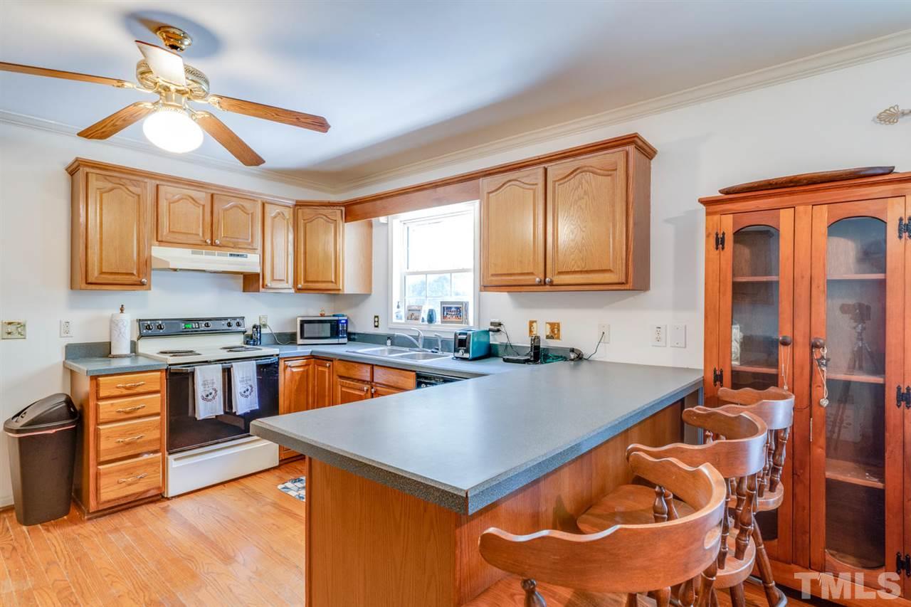 190 Landmark Road Willow Spring, NC 27592 - Photo 7 of 25 a kitchen with a stove a sink and a refrigerator
