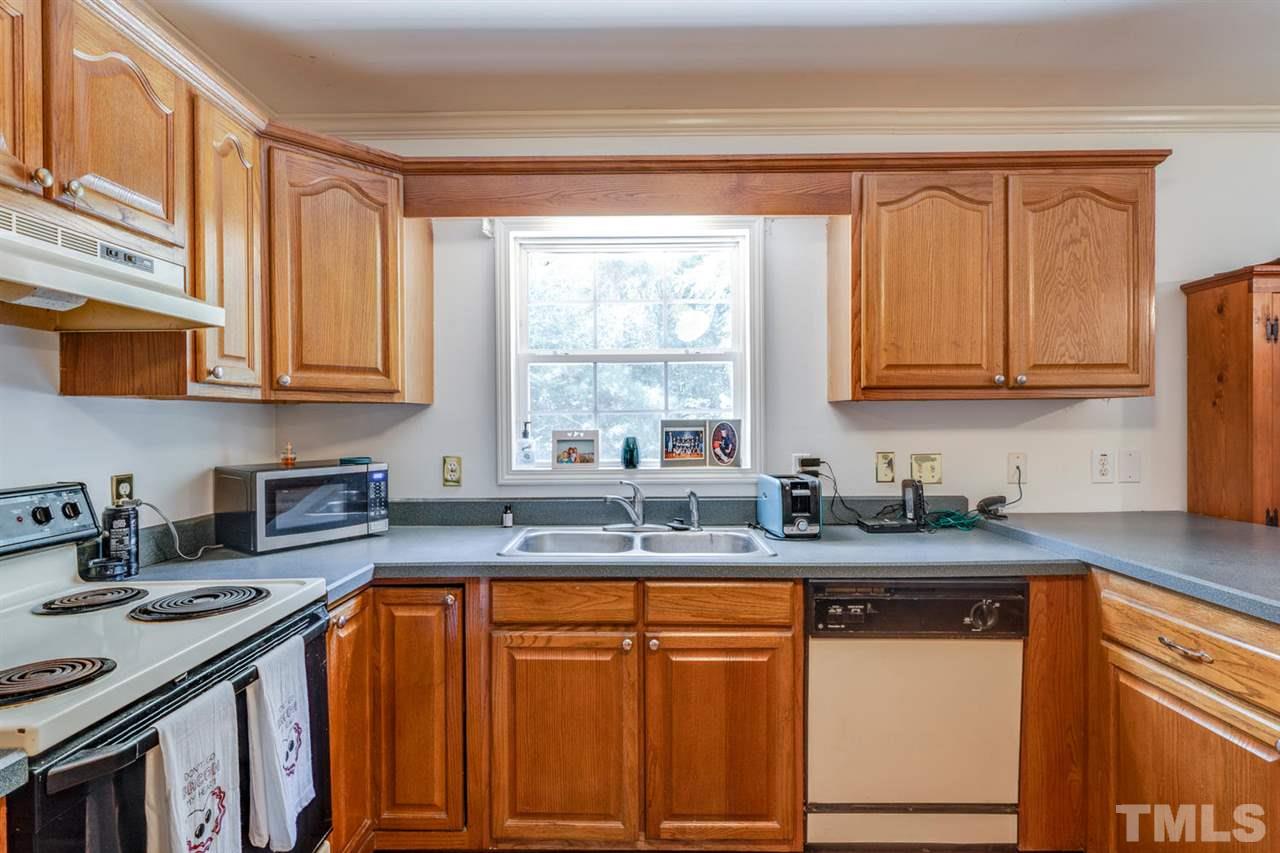190 Landmark Road Willow Spring, NC 27592 - Photo 8 of 25 a kitchen with stainless steel appliances granite countertop a sink stove and cabinets