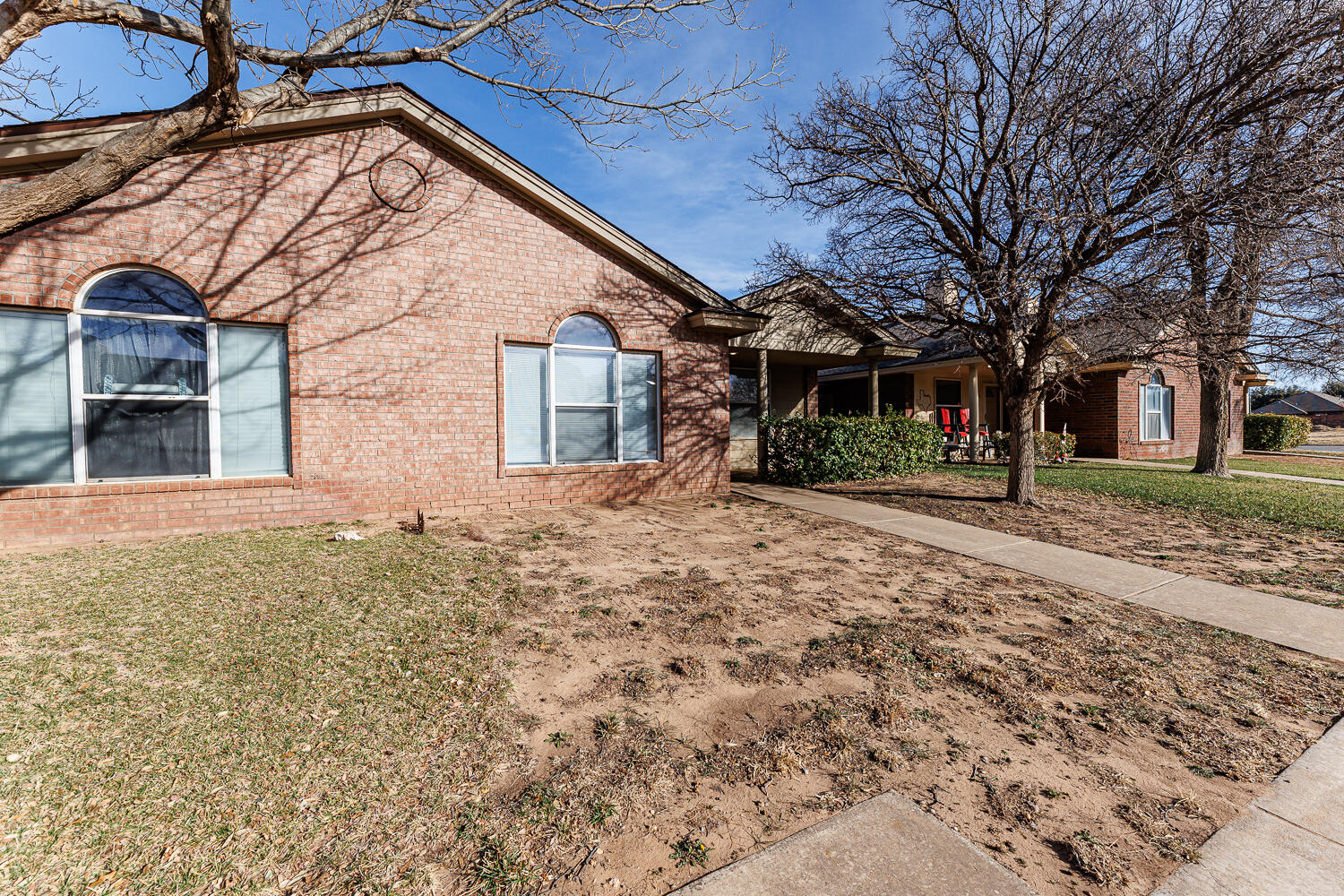 9713 Joliet Avenue Lubbock, TX 79423 - Photo 1 of 18 a backyard of a house with large trees and brick walls