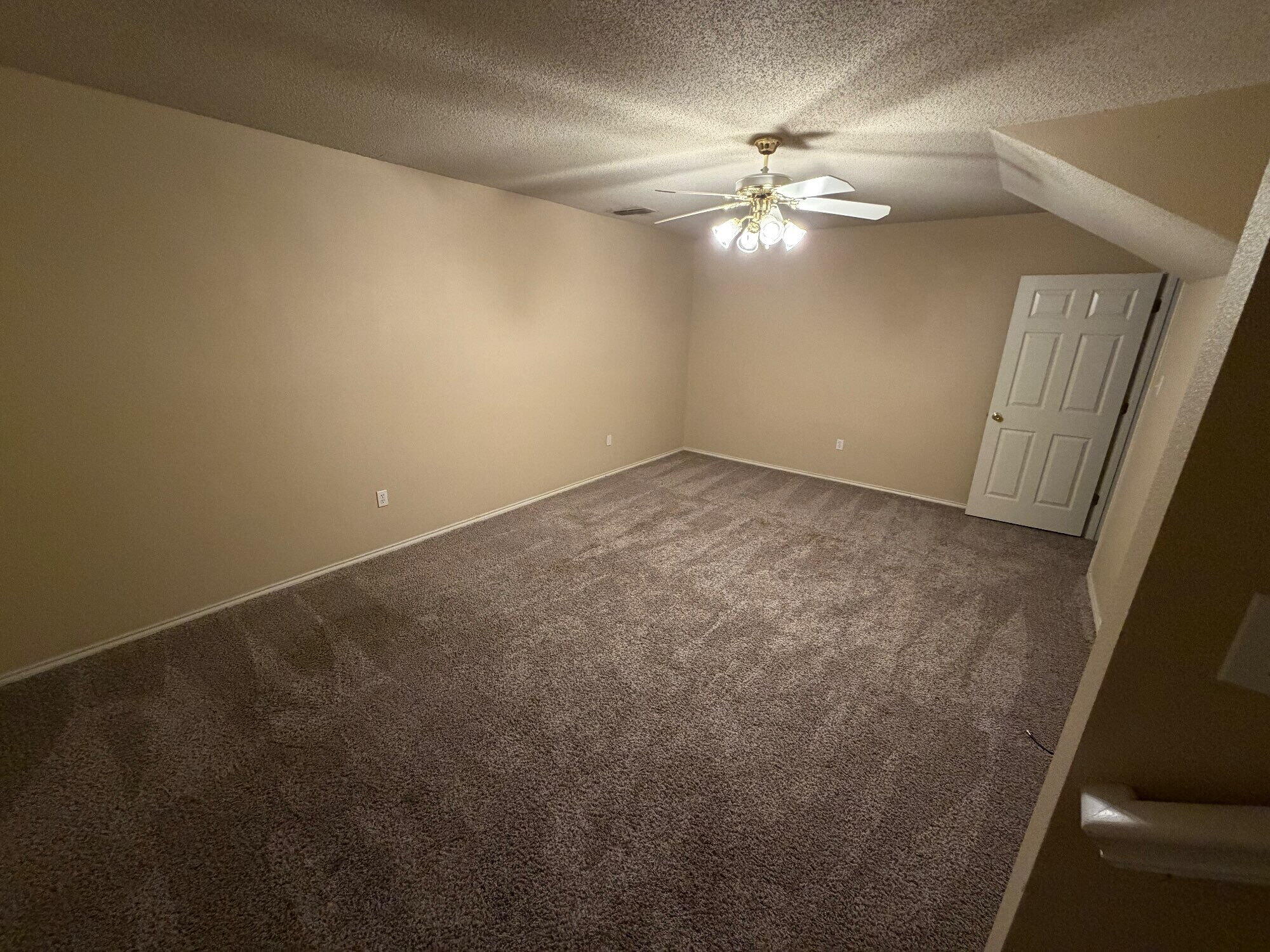9713 Joliet Avenue Lubbock, TX 79423 - Photo 14 of 18 an empty room with a chandelier fan and windows