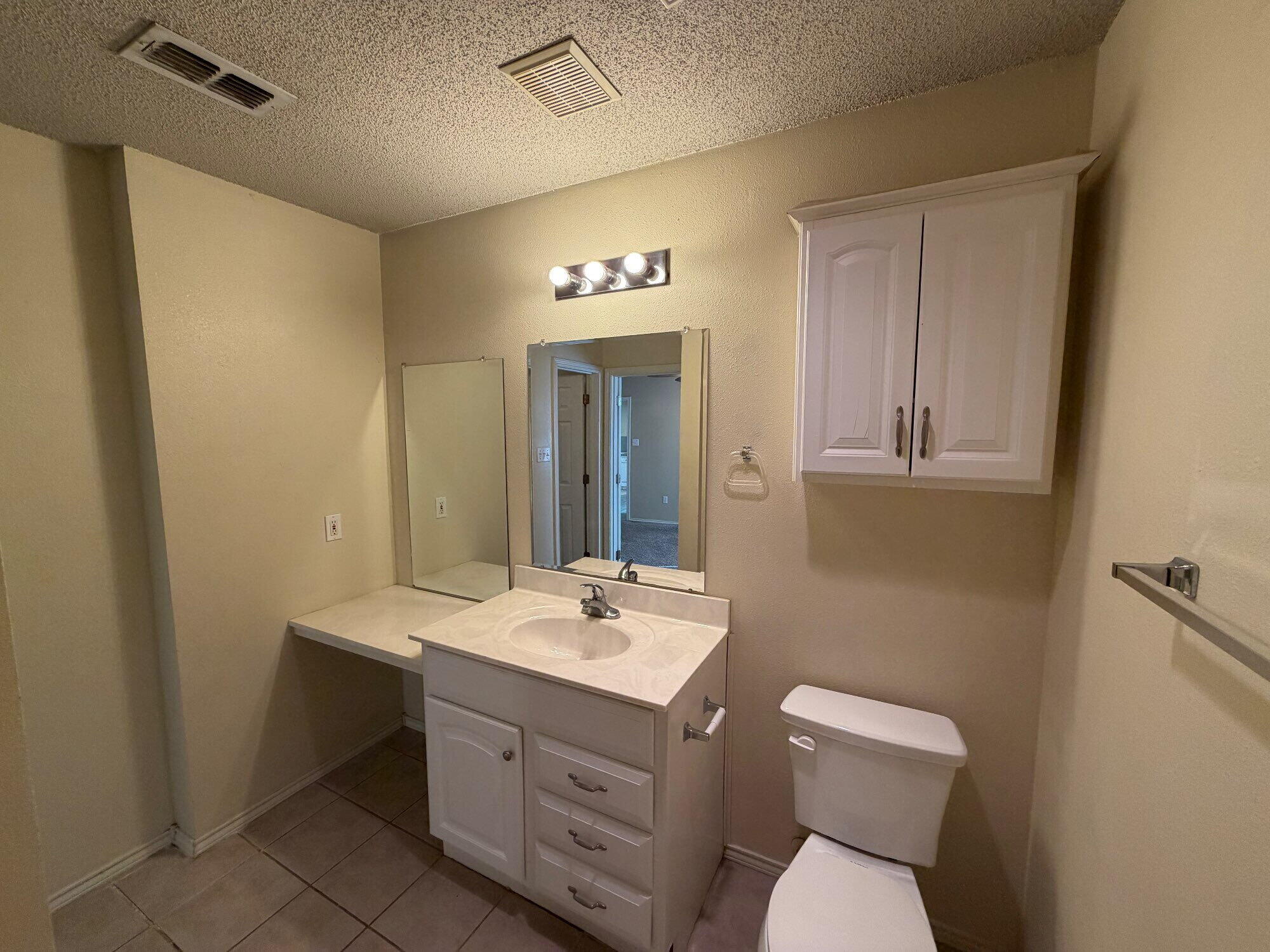 9713 Joliet Avenue Lubbock, TX 79423 - Photo 15 of 18 a bathroom with a toilet sink and mirror