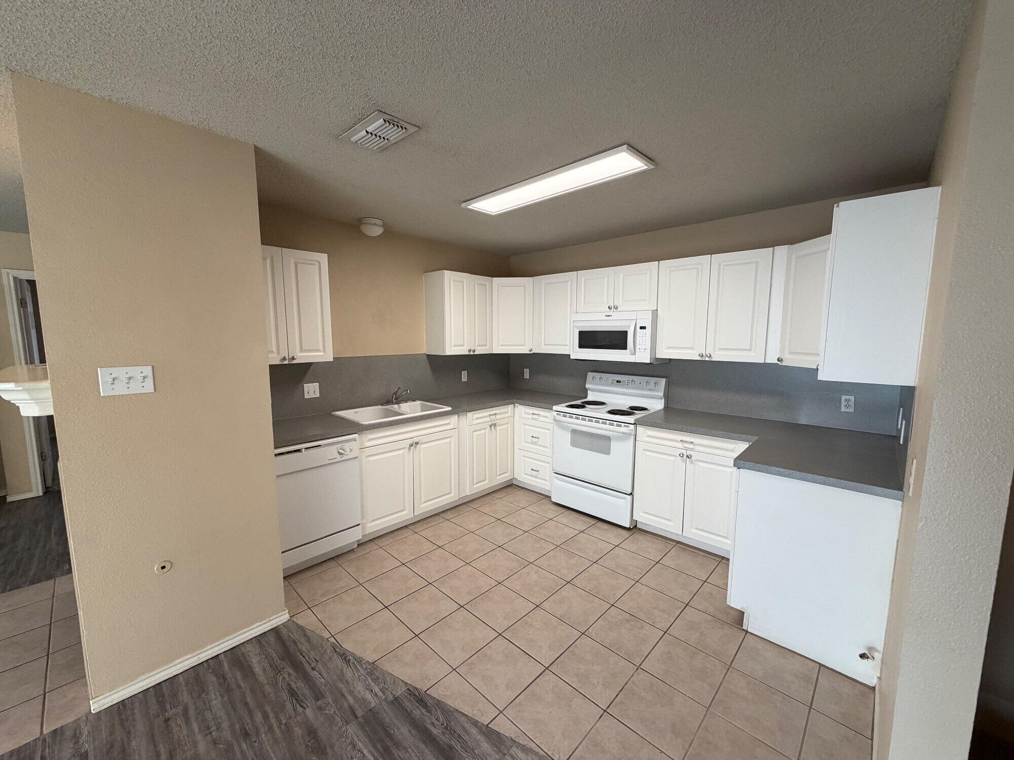 9713 Joliet Avenue Lubbock, TX 79423 - Photo 10 of 18 a kitchen with granite countertop white cabinets and white appliances
