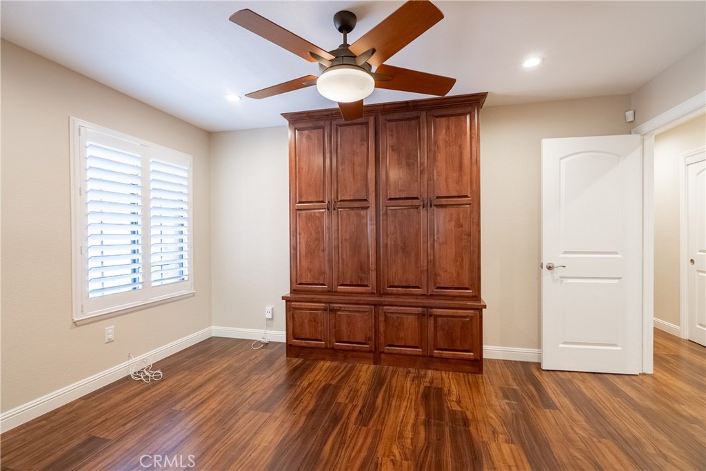 5965 Maybrook Circle Riverside, CA 92506 - Photo 13 of 25 an empty room with wooden floor closet fan and windows