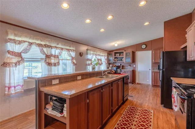 a kitchen with stainless steel appliances granite countertop a sink and a refrigerator