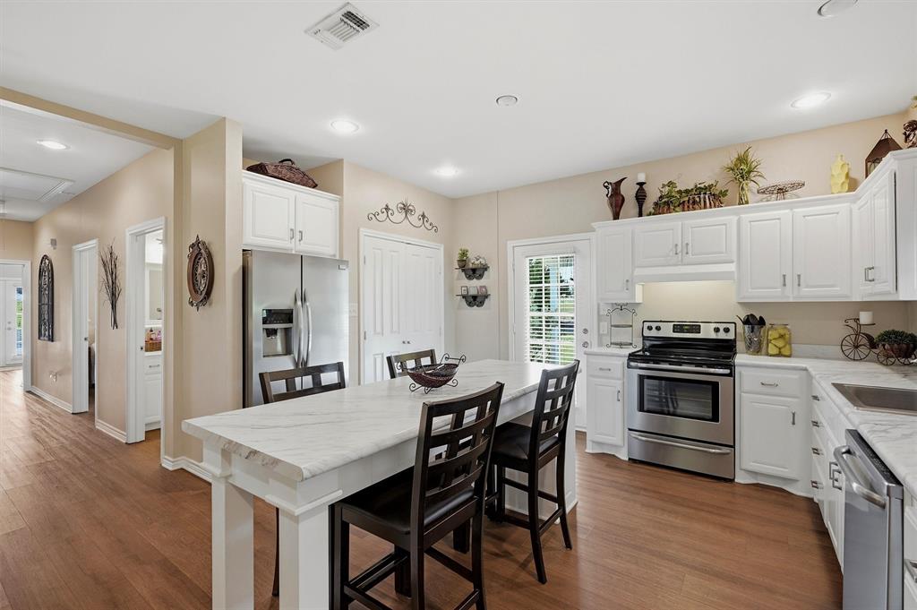 15656 South State Highway 78 Blue Ridge, TX 75424 - Photo 13 of 36 a kitchen with stainless steel appliances a stove a refrigerator a white table and chairs