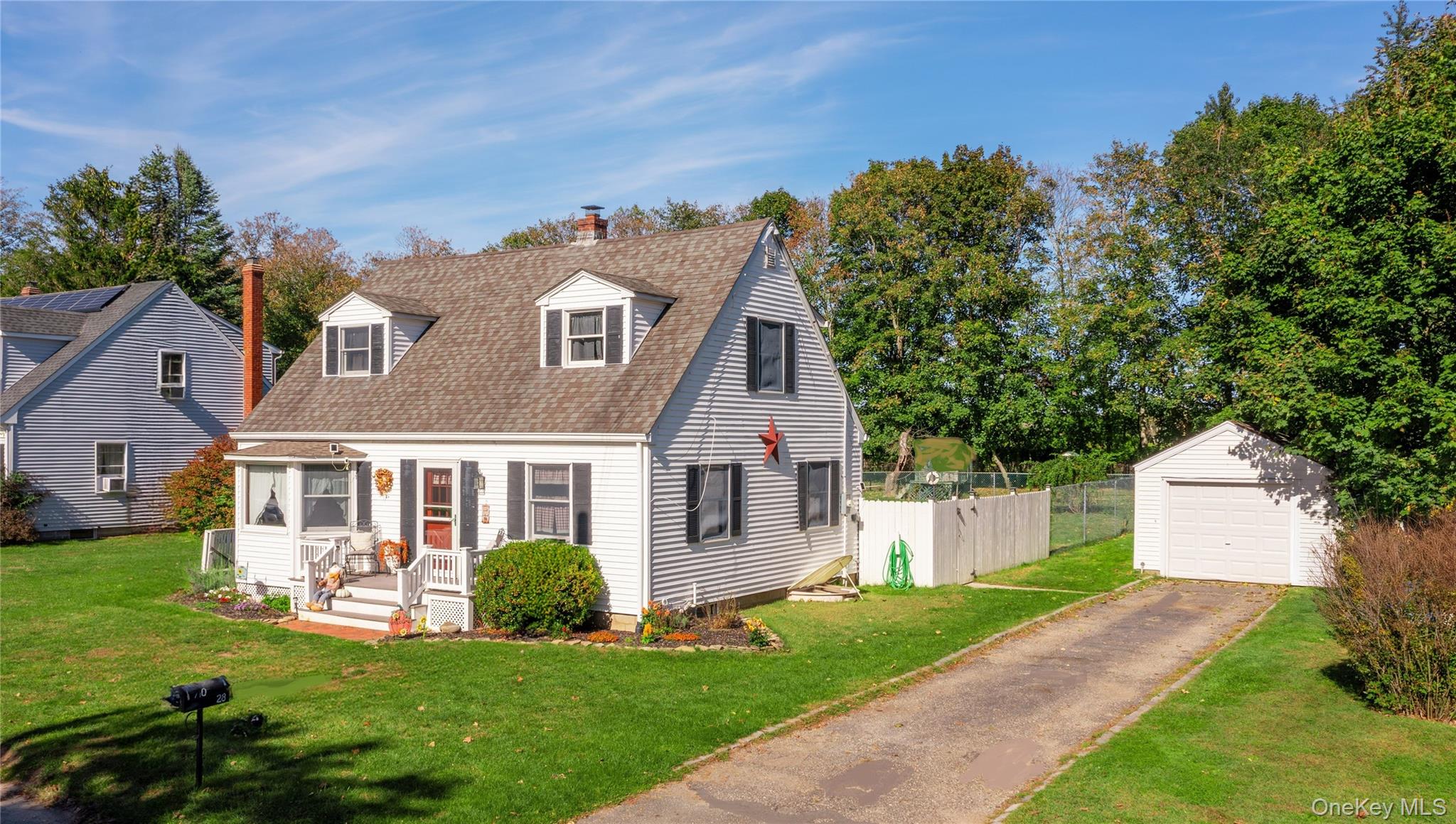 28-aka 710) Sound Road Greenport, NY 11944 - Photo 2 of 26 Cape cod home with a chimney, an outdoor structure, roof with shingles, and a garage