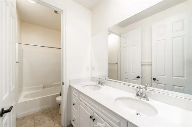 a bathroom with a tub sink vanity and a mirror