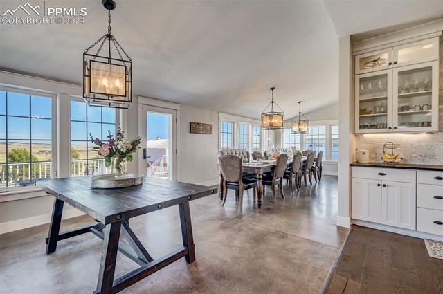 24076 Kobilan Road Calhan, CO 80808 - Photo 14 of 50 Dining area with a notable chandelier, concrete flooring, and lofted ceiling